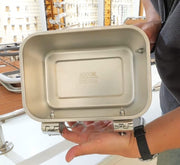bait box with '3000ML' marking held by a person indoors.