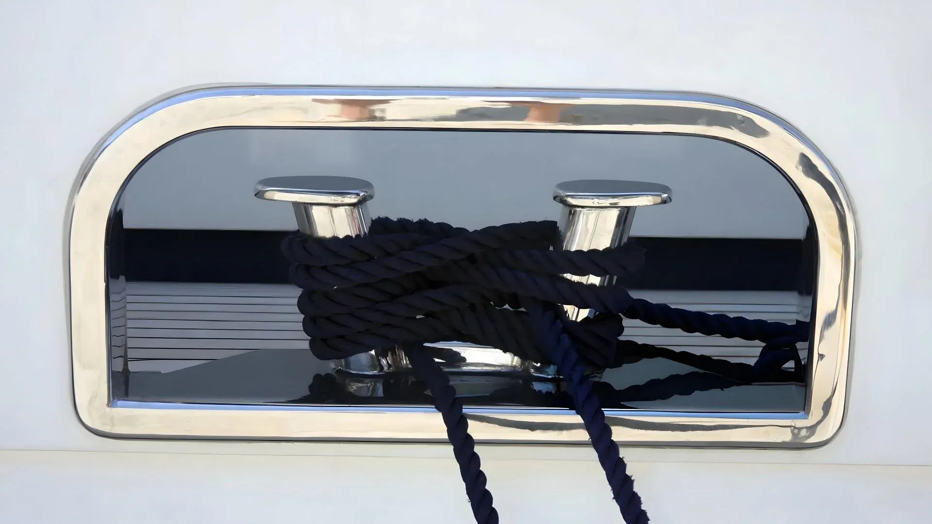 Nautical cleat with black rope on a white background