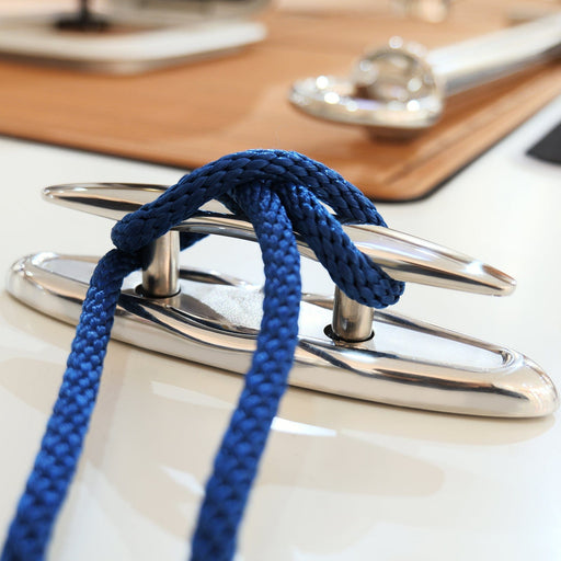 Blue rope tied to a metallic cleat on a boat