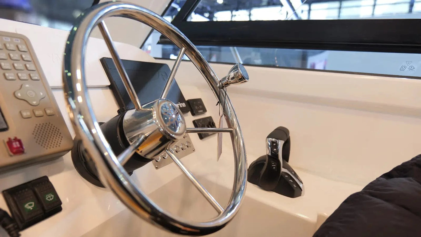Close-up of a boat's steering wheel and dashboard controls.